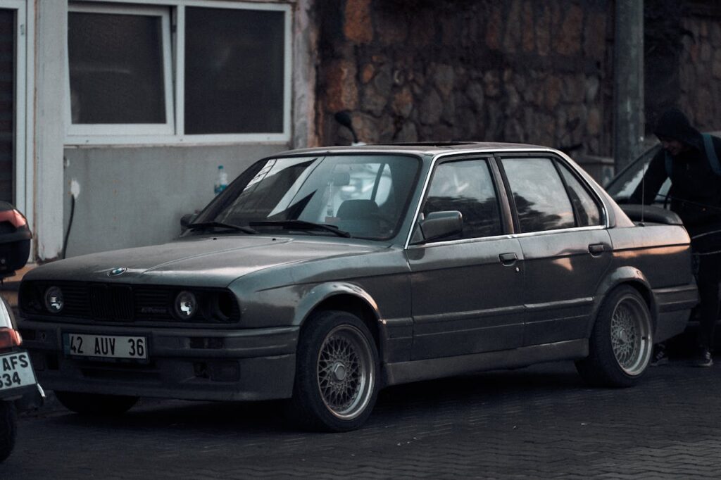 A classic BMW E30 parked outdoors, exuding vintage charm with its timeless design.